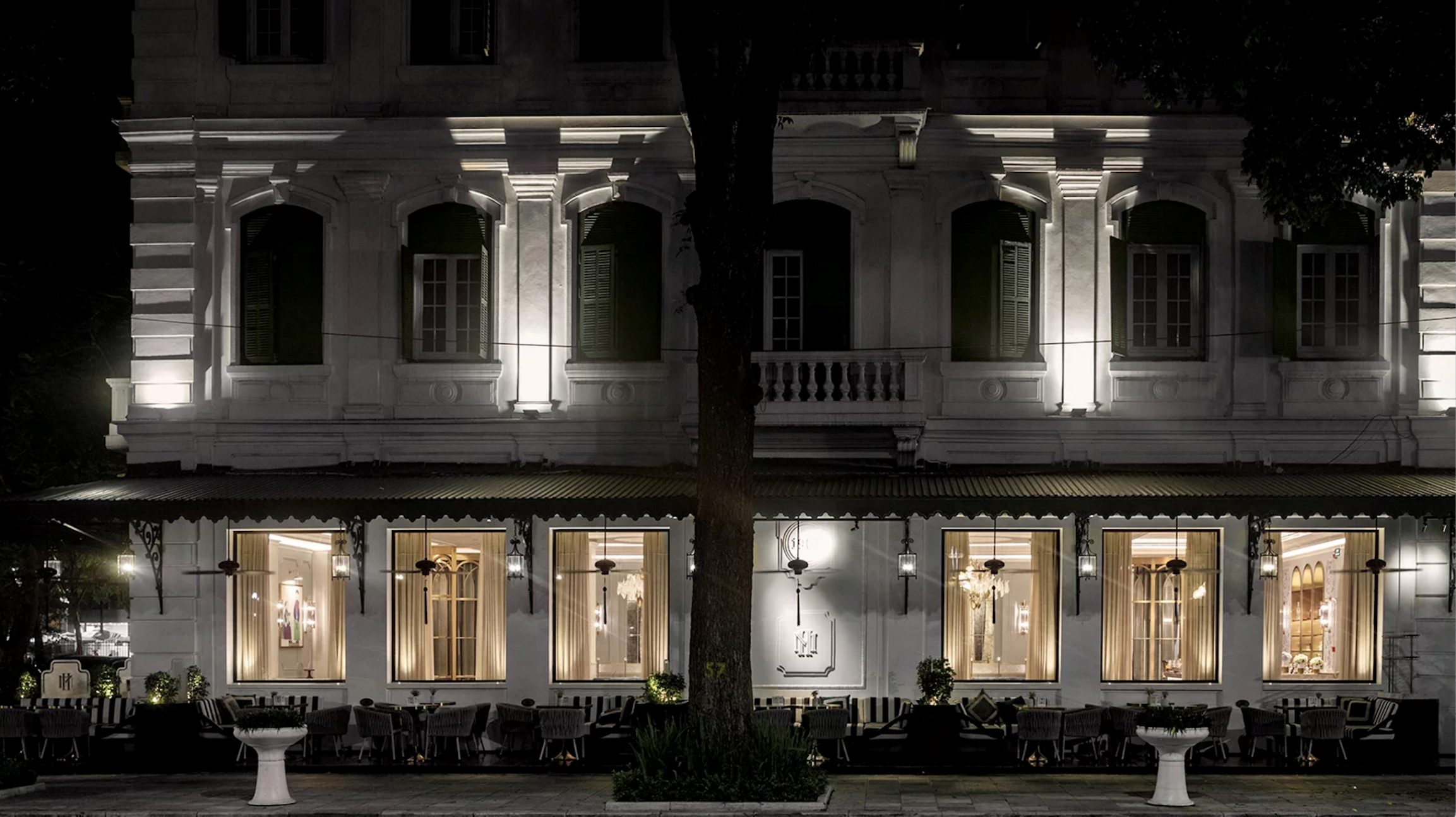 Hospitality façade and terrace at night with architectural lighting